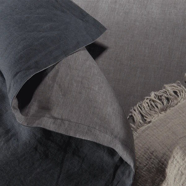 Close-up of charcoal linen fabric texture and pillowcase hem detail